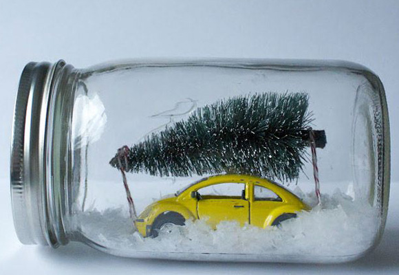 Escena navideña en un frasco de vidrio con un coche de juguete