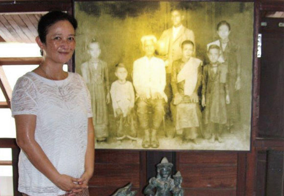 Sophea junto a una foto de su familia