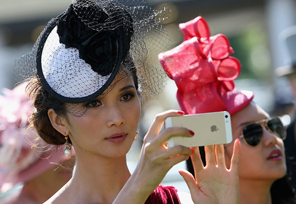 ASCOT, ENGLAND - JUNE 17: Lady takes a photograph on her phone during day one of Royal Ascot at Ascot Racecourse on June 17, 2014 in Ascot, England. (Photo by Chris Jackson/Getty Images for Ascot Racecourse)